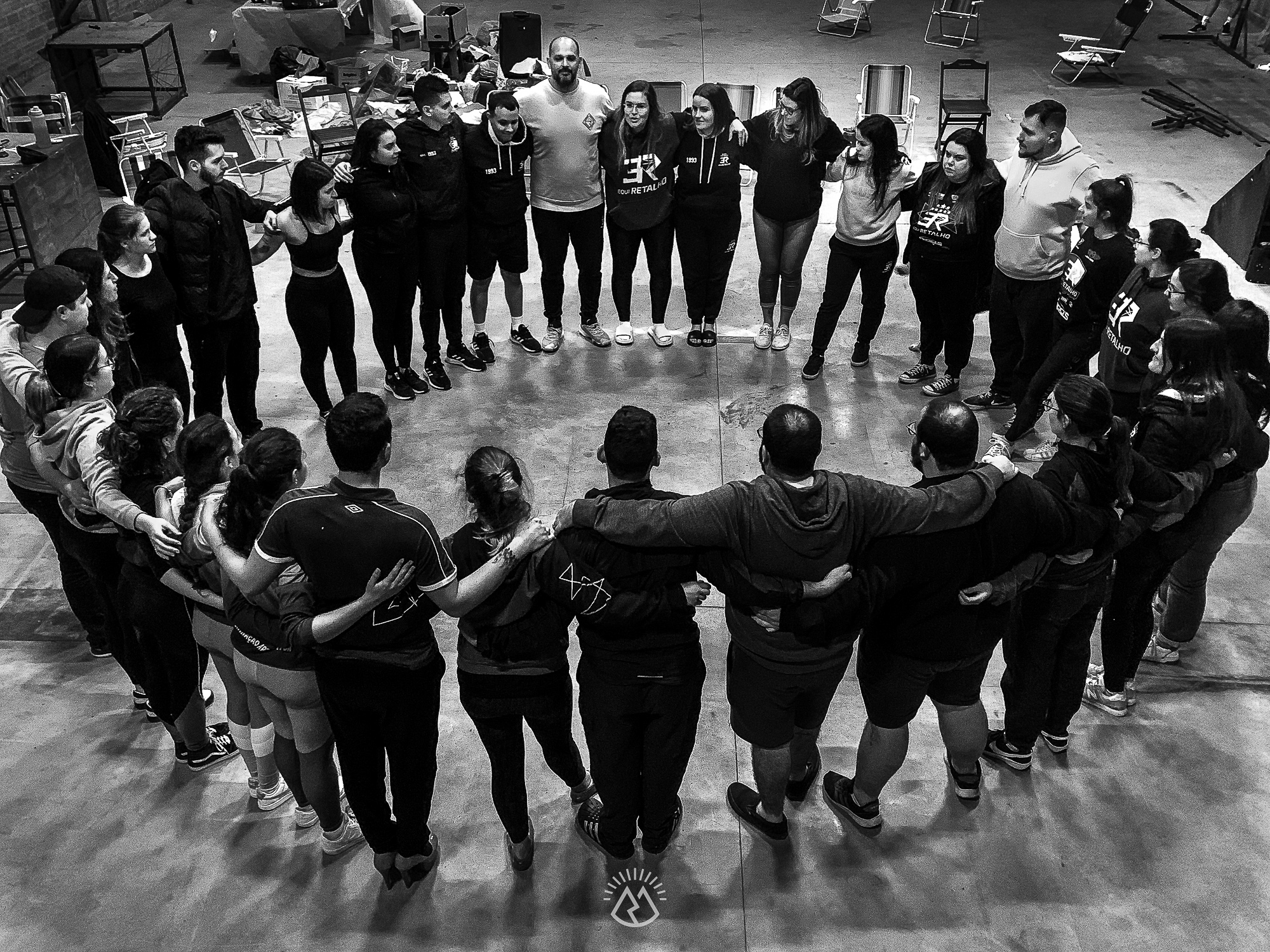 Elenco da EquiRetalho reunido em círculo durante ensaio — foto em preto e branco